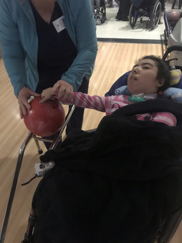 child with hand on bowling ball