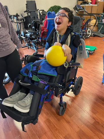 child holding ball while laughing