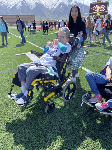child sitting in wheelchair on the field 